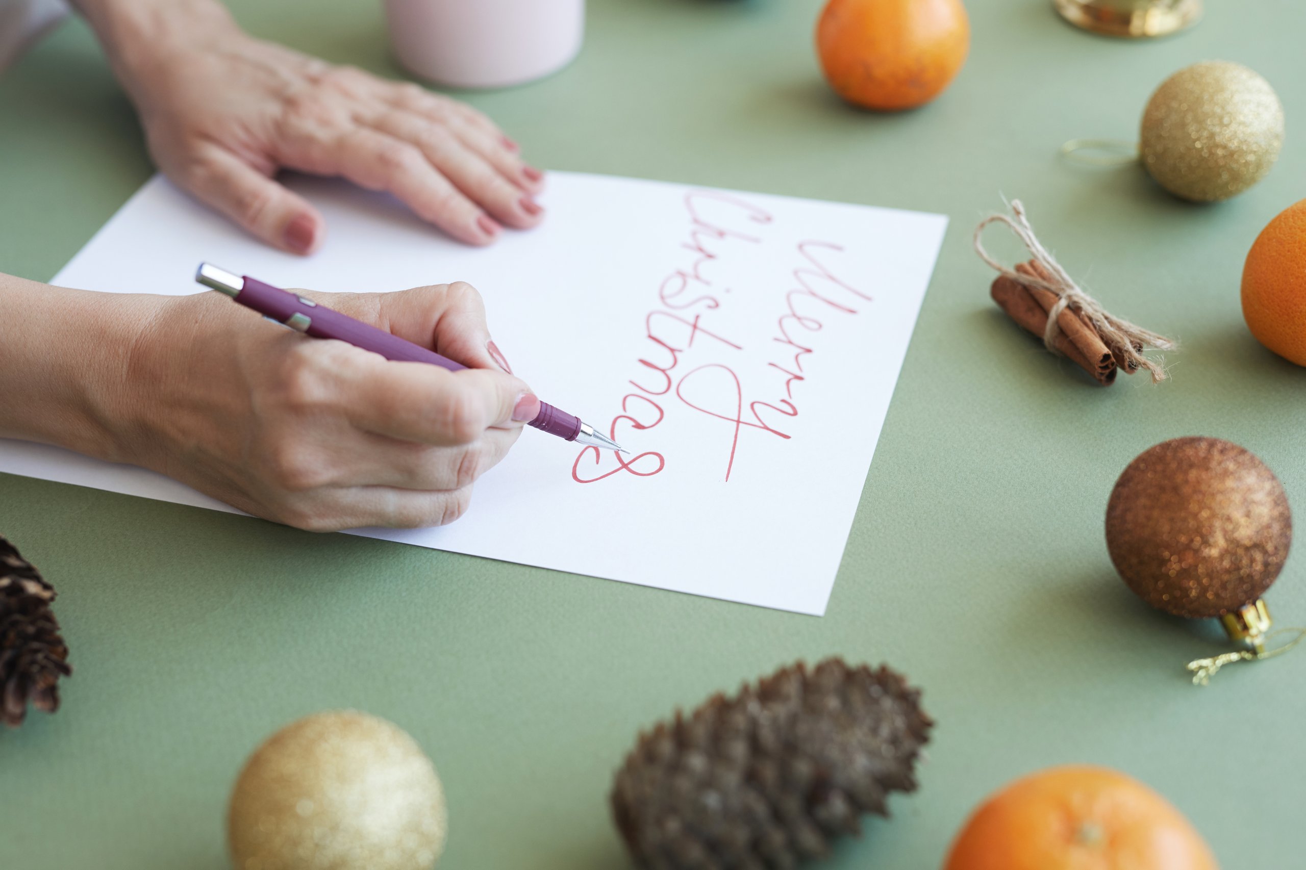 Hand lettert eine Weihnachtskarte mit Stift und Papier